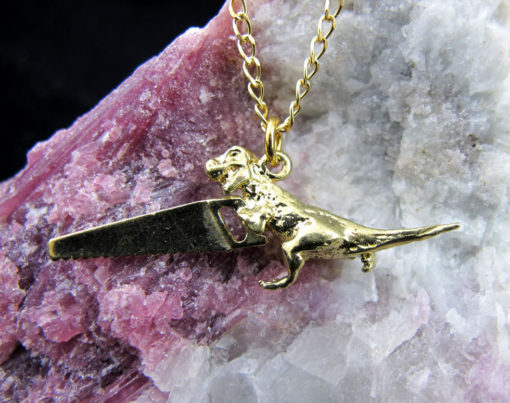 T rex holding saw "dinosaw"necklace on dainty cable chain