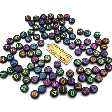 Premium Photo  Black plastic beads with colored letters placed